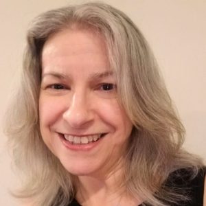 A person smiling at the camera Description automatically generated