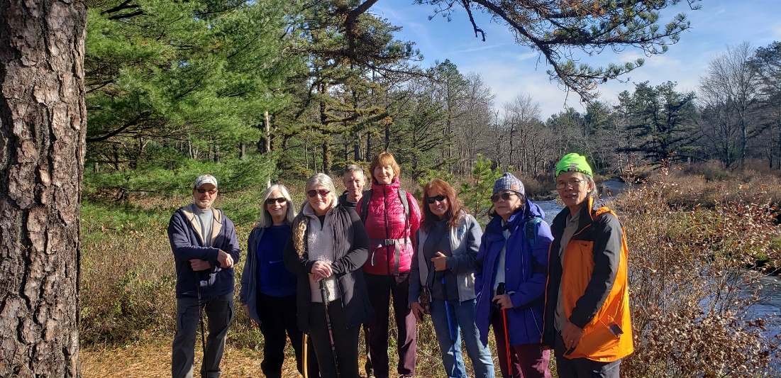 A group of people standing in a forest Description automatically generated