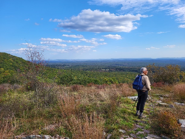 A person hiking on a trail

Description automatically generated