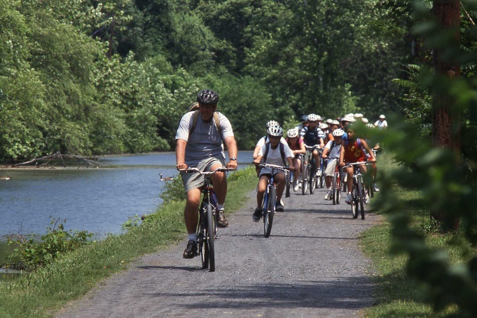 A group of people riding bicycles on a trail
Description automatically generated