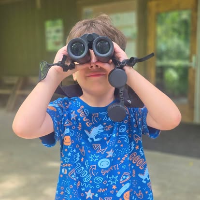 A child holding binoculars over his eyes AI-generated content may be incorrect.