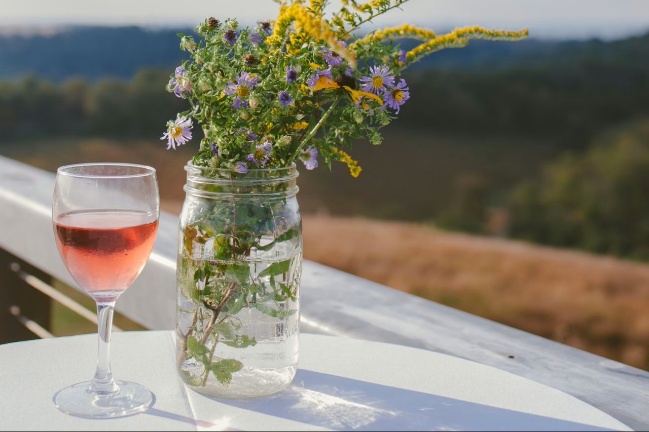 A glass of wine and flowers AI-generated content may be incorrect.