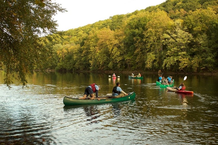 A group of people in canoes on a river AI-generated content may be incorrect.